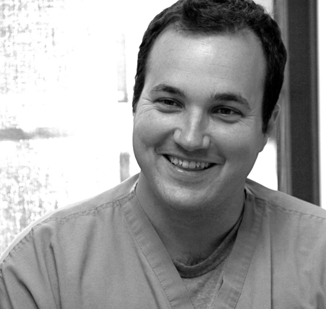 Dr. Beau J. Brasseale, smiling, in blue scrubs