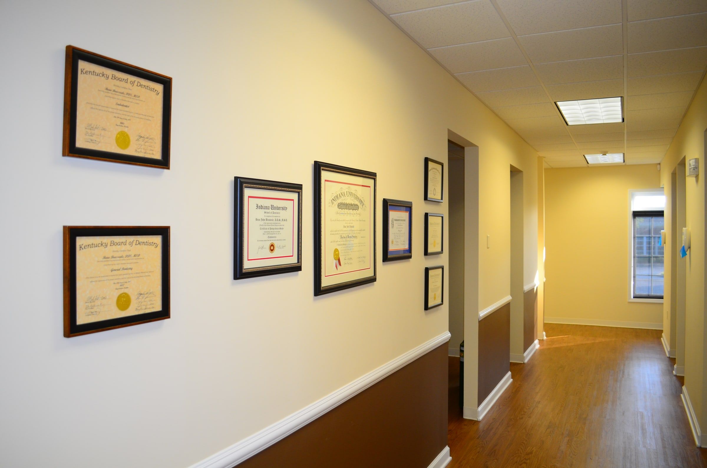 The hallway lined with framed diplomas and Kentucky Board of Dentistry licenses